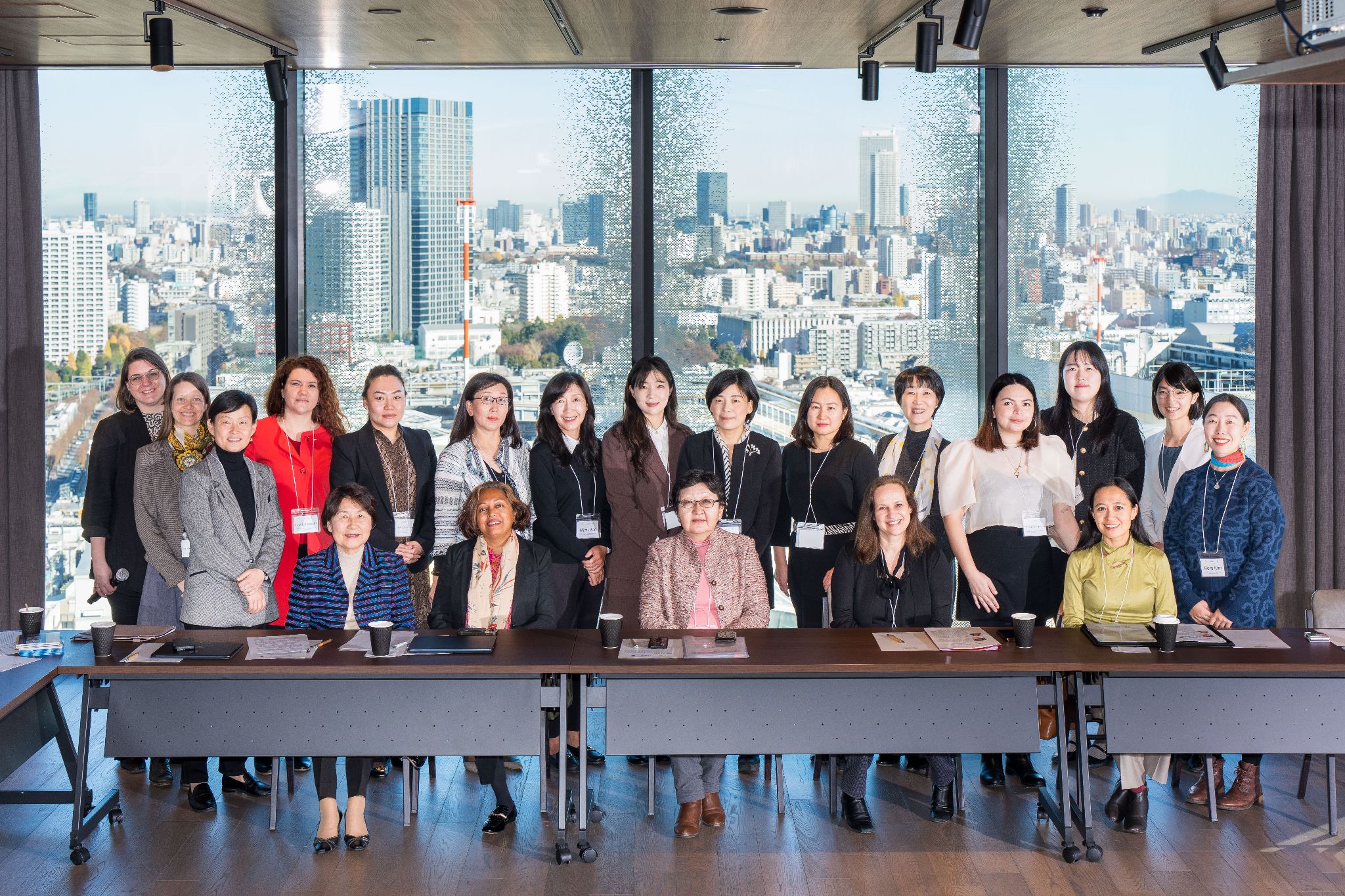 A group of people standing in a roomDescription automatically generated