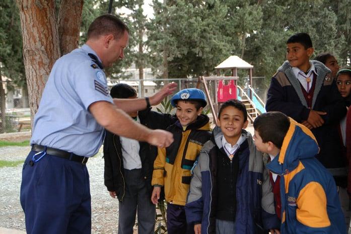 unpol officer with greek cypriot and turkish cypriot children in pyla the only mixed village in the un buffer zone